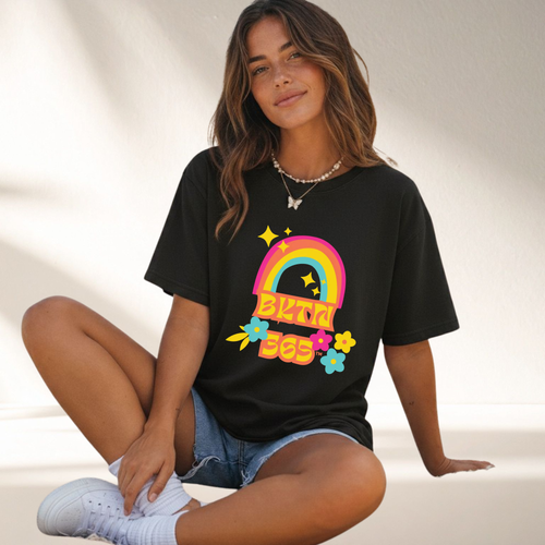 Be Kinder Than Necessary 365 Shirt featuring a colorful retro rainbow and flowers printed on a black unisex graphic t-shirt.